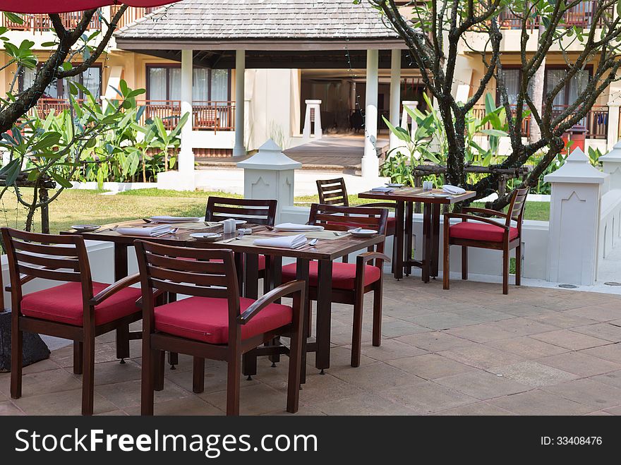 Open-air restaurant on a background of palm trees with garlands