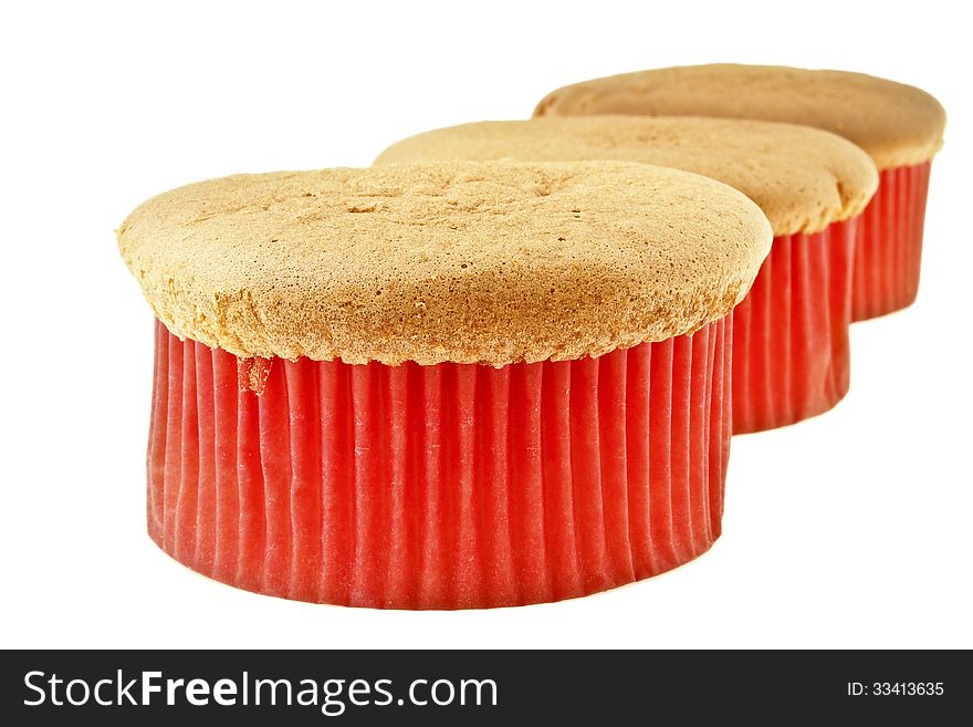 Row of three sponge cake in red paper cup on white background. Row of three sponge cake in red paper cup on white background