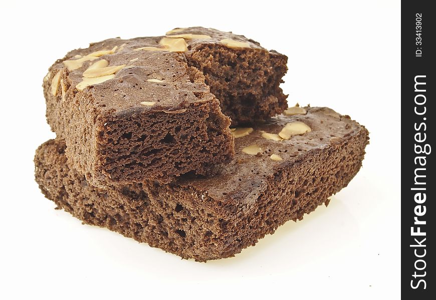 Cross stack of eating almonds brownies on full brownies cake on white background. Cross stack of eating almonds brownies on full brownies cake on white background