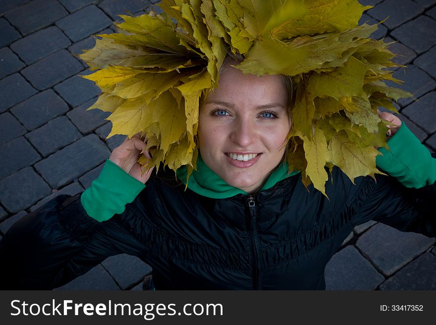 Photo of the girl in a headdress of yellow leaves. Photo of the girl in a headdress of yellow leaves