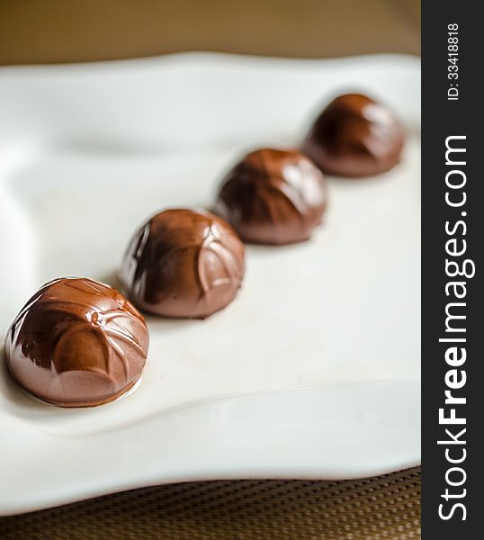 Closeup of chocolate candies in white plate