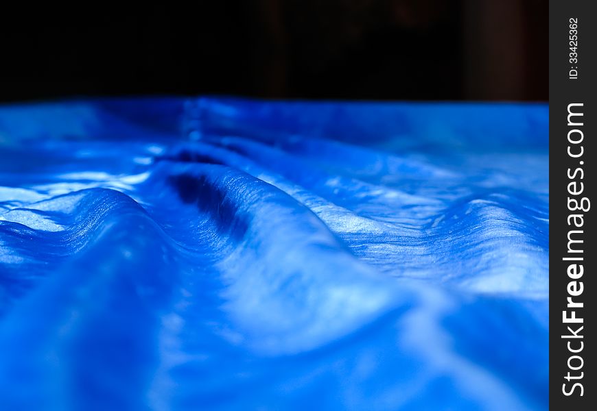 Detail of the cover of a billiard table with blue silk. Detail of the cover of a billiard table with blue silk.