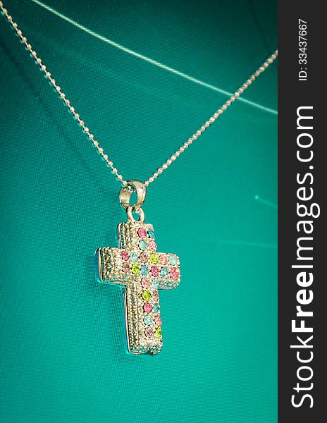 Silver Cross necklace on green screen.