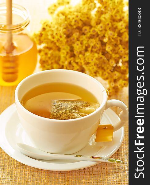 Medicinal herbal tea in white cup with honey. Medicinal herbal tea in white cup with honey
