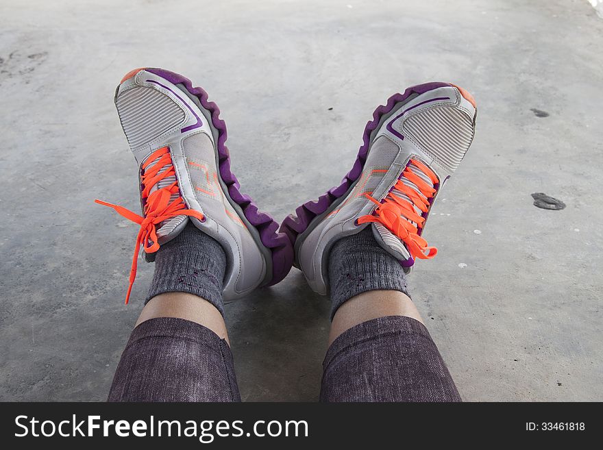 Relaxing feet posture in sneaker with bright orange colored shoelace