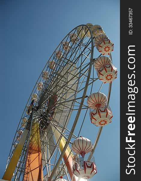 A Ferris wheel (also known as an observation wheel or big wheel) is a nonbuilding structure consisting of a rotating upright wheel with passenger cars (sometimes referred to as gondolas or capsules) attached to the rim in such a way that as the wheel turns, the cars are kept upright, usually by gravity.