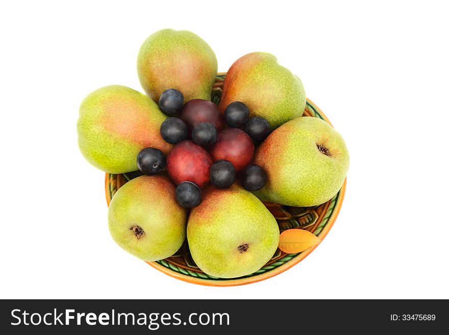 Large ripe pears, plums on a ceramic plate. Presented on a white background. Large ripe pears, plums on a ceramic plate. Presented on a white background.