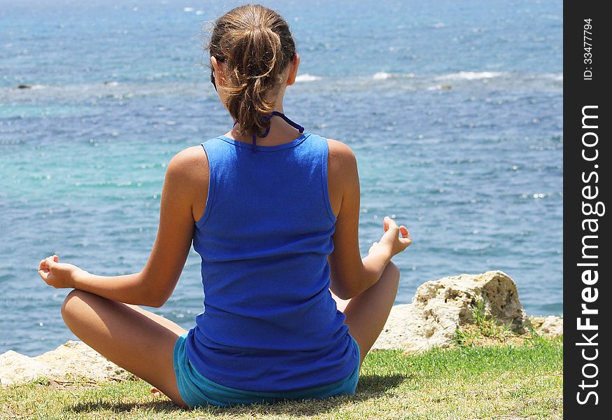 Beautiful girl on the beach meditating, blue body concentration contemplation dawn edge exercise female health healthy