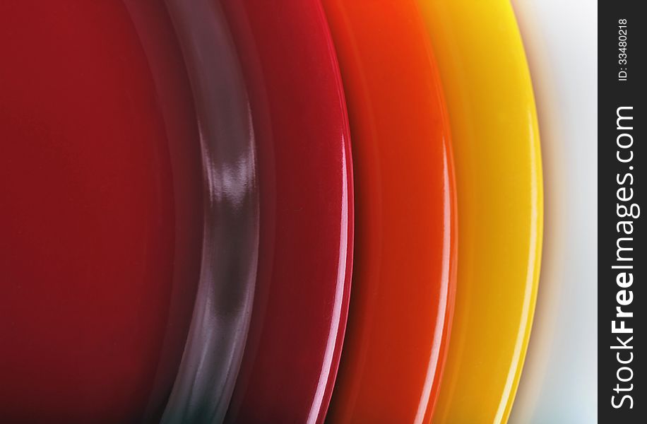 Orange, yellow and red colored plates stacked upon each other. This set of kitchen ware is made of melamine plastic. Orange, yellow and red colored plates stacked upon each other. This set of kitchen ware is made of melamine plastic