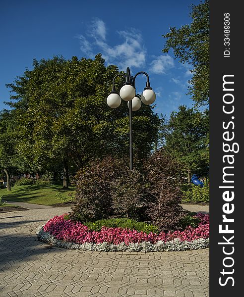 Lamppost in a park surrounded by trees and flowers