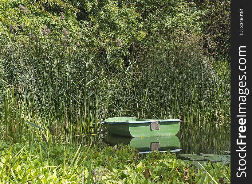 Fisherman's boat moored ad the trunk between bulrush. Fisherman's boat moored ad the trunk between bulrush.