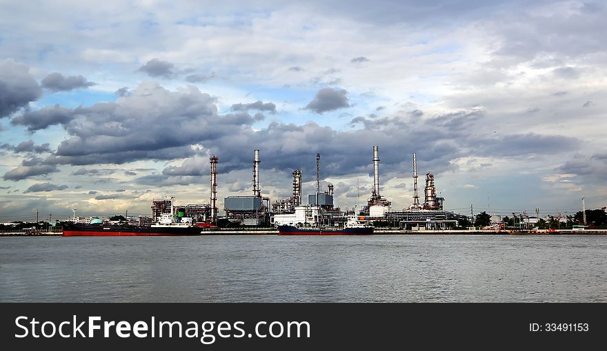 Oil refinery with thunderstorm background
