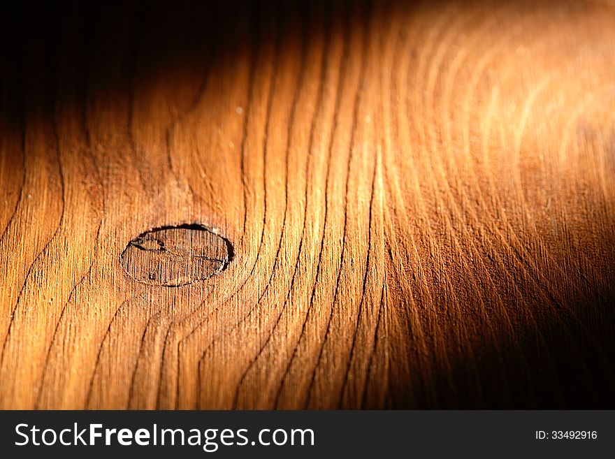 Nice wooden background with knot under beam of light