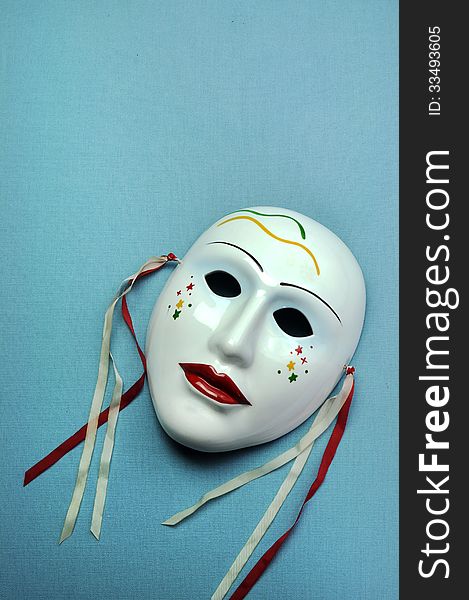 Pale blue ceramic mask. Vertical with copy space.