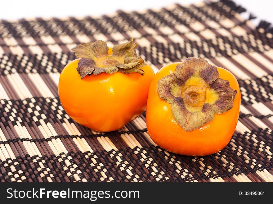 Persimmon fruit on bamboo mat