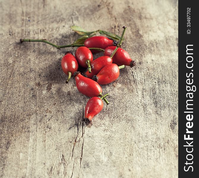 Rose hips on a wooden table, close up photo