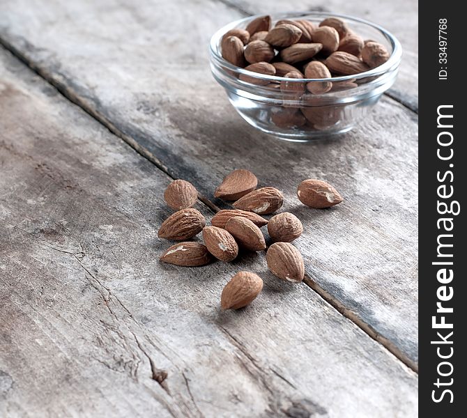 Roasted almonds on wooden table, food background