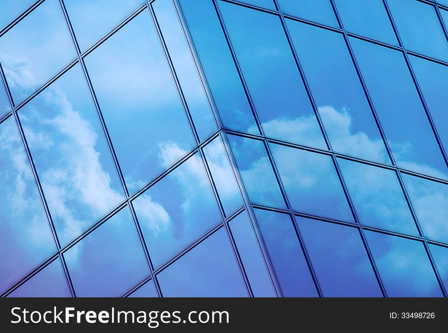 Clouds reflected in windows of modern office building