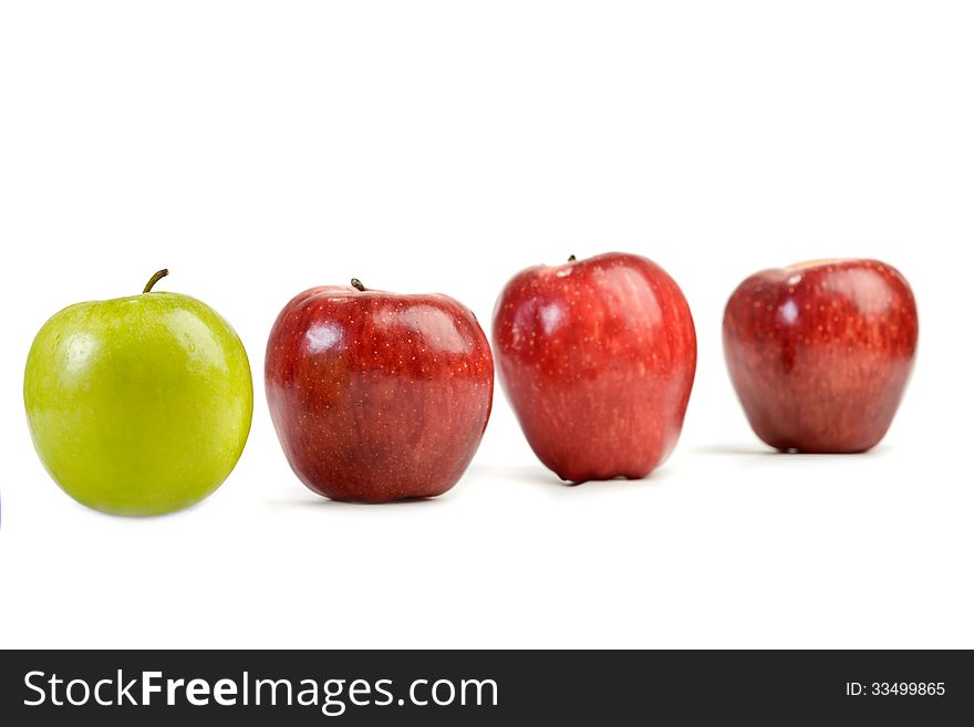 Ripe red apples and one green apple on white