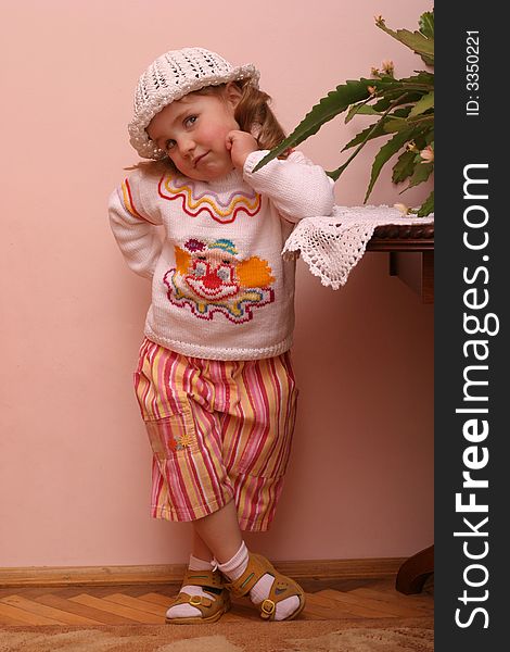 Little girl in funy clothes pose over interior wall