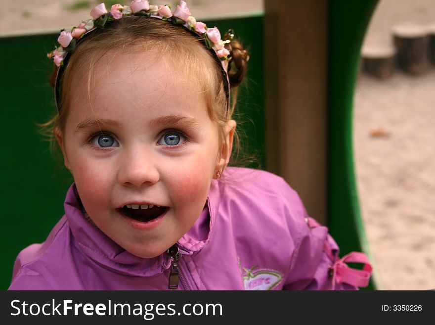Smiley little girl over defocused playground background