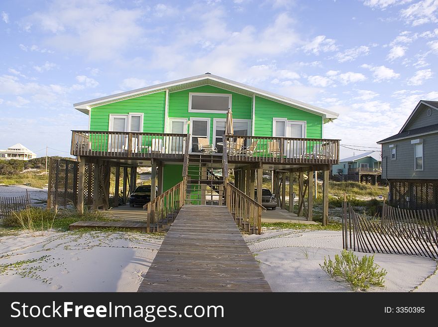 Bright green house on beach with deck and boardwalk. Bright green house on beach with deck and boardwalk