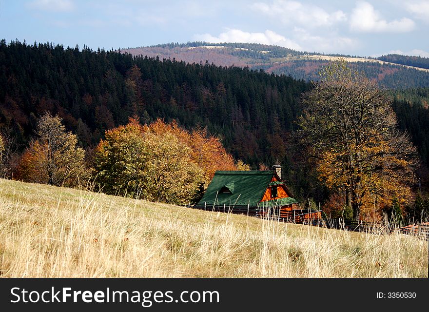 Mountain cottage among forests and meadows in autumn. Mountain cottage among forests and meadows in autumn