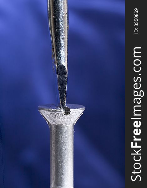 A close up of a screwdriver tightening a screw. A close up of a screwdriver tightening a screw