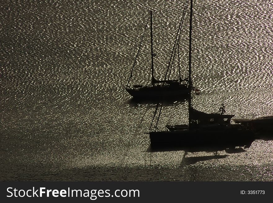 Sailing boats anchored in a harbour at sunrise. Sailing boats anchored in a harbour at sunrise