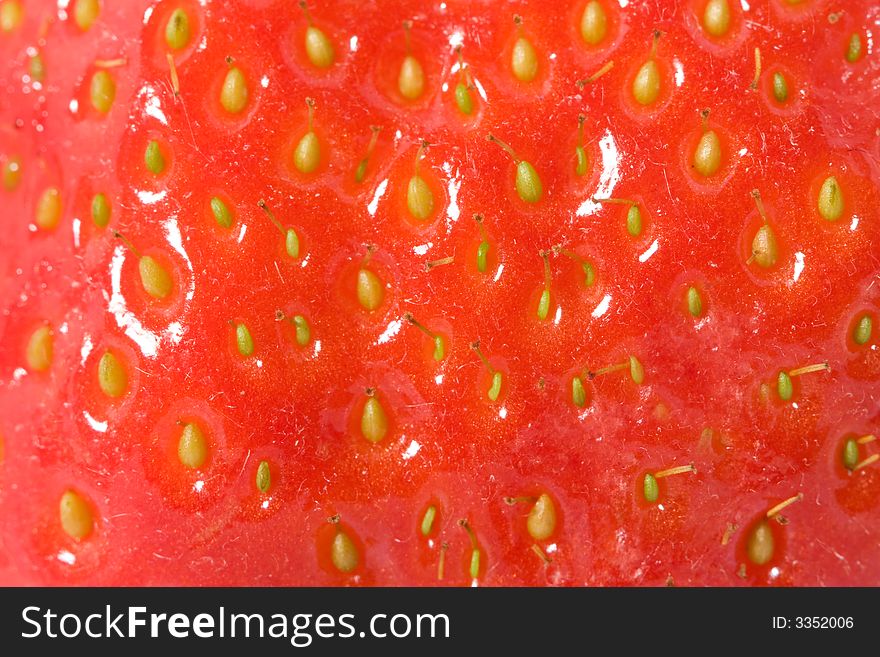 Ripe strawberry macro. Red background.