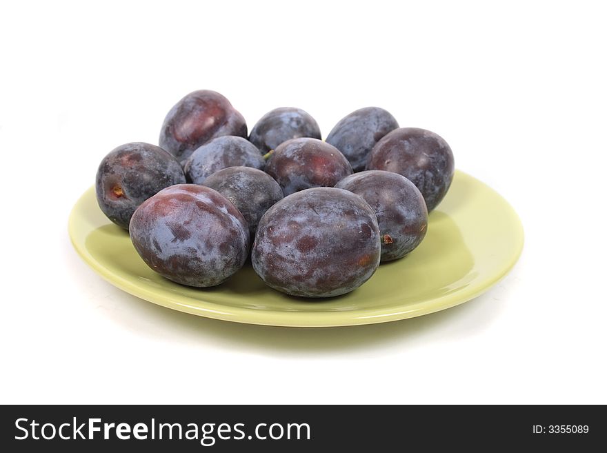 Plums on the green table on the white background