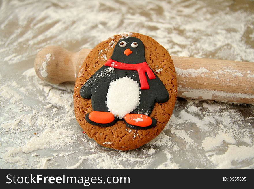 Cute penguin cookie rests on the rooling pin