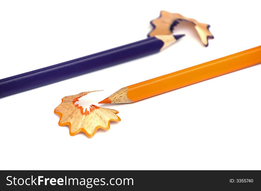 Orange and Purple Pencils just sharpened. Opposite directions. White background. Isolated. Shallow dof. Orange and Purple Pencils just sharpened. Opposite directions. White background. Isolated. Shallow dof.