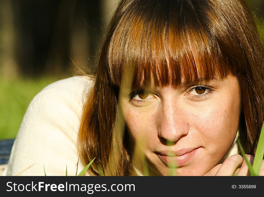 Young girl lying on the grass, close portrait