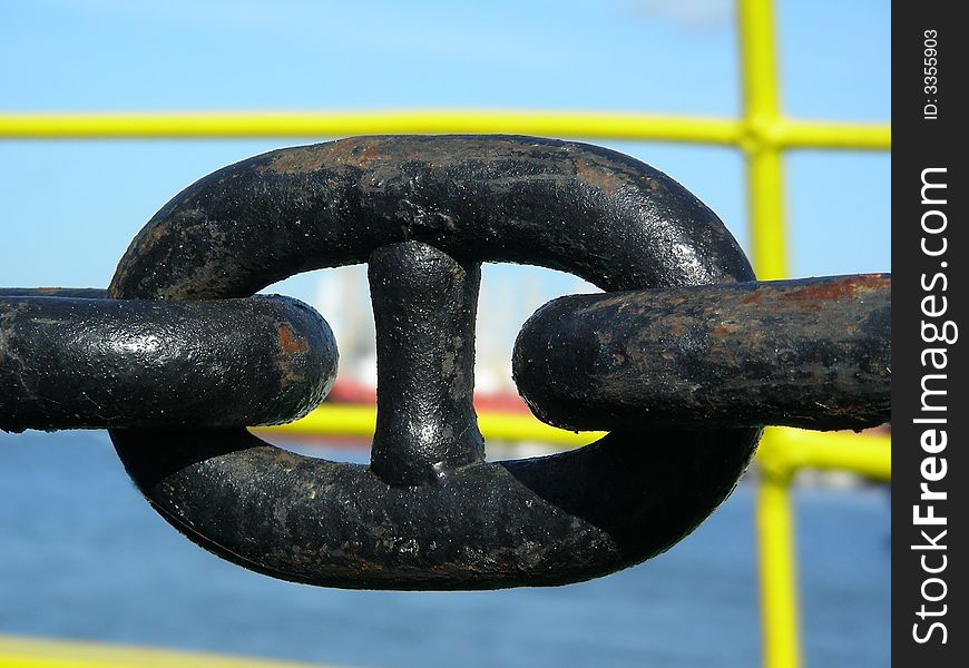 Rusty, black metallic anchor chain on a ship