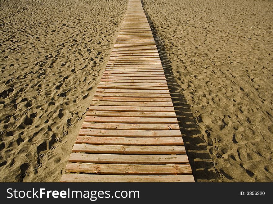 A wood way on the sand in a beach of Fuerteventura in the Canary Islands. A wood way on the sand in a beach of Fuerteventura in the Canary Islands
