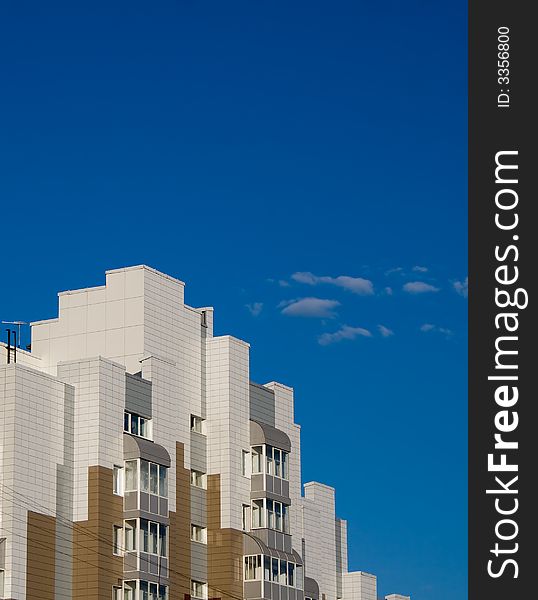 Photo of toy like building with bkue sky on the background. Poster-like picture.