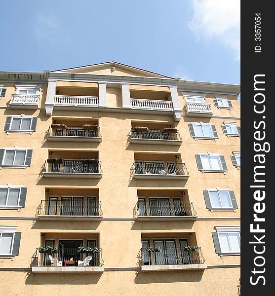 A pink stucco condo tower with balconies. A pink stucco condo tower with balconies