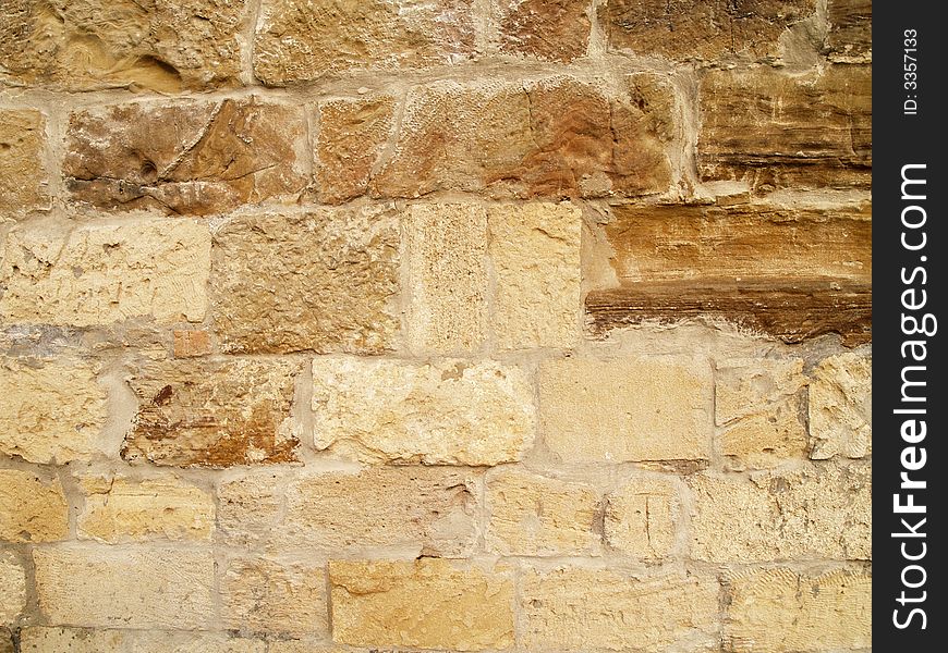 Horizontal view of a layered, sandstone exterior wall building facade. A close up of a brick wall which can be used as background. Horizontal view of a layered, sandstone exterior wall building facade. A close up of a brick wall which can be used as background