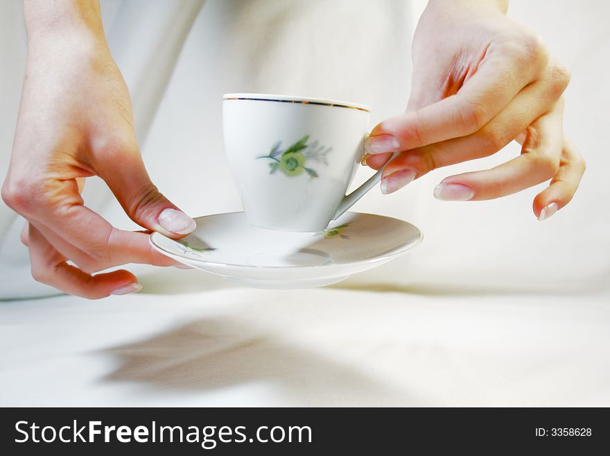 Two hands holding a cup and a saucer. Two hands holding a cup and a saucer