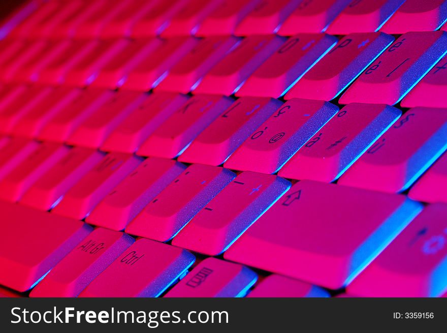 Close-up photo of the keyboard of an open notebook; blue red tone. Close-up photo of the keyboard of an open notebook; blue red tone