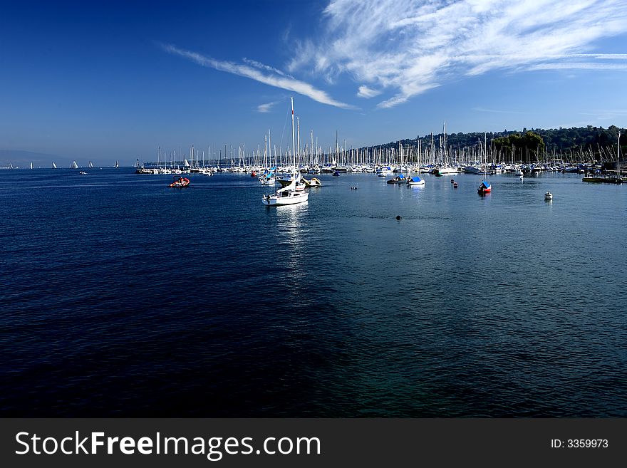 Ships in Leman Lake construct typical Swiss scenery. Floating clouds in the sky express a warm day.