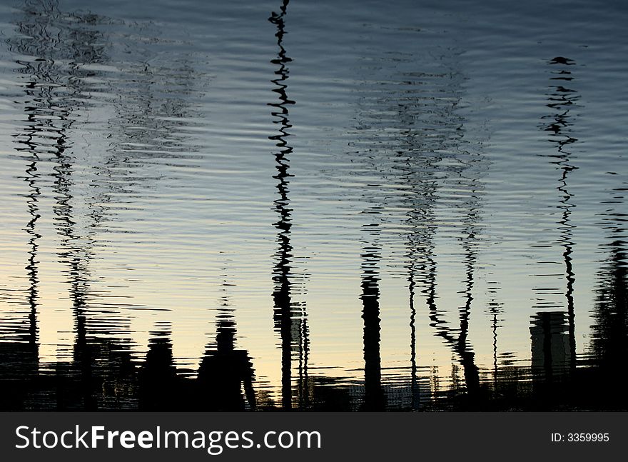 Silhouettes reflected on water on a park