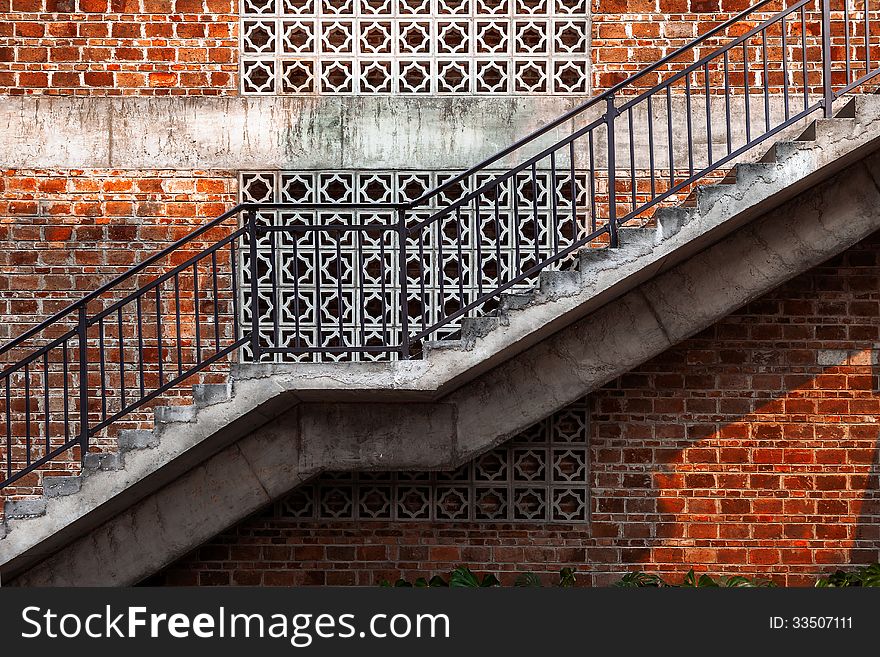 Outdoor staircase with a red brick wall