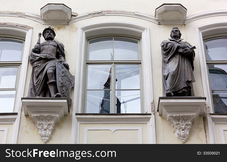 Two bronze statues on the facade of a historic palace. Two bronze statues on the facade of a historic palace