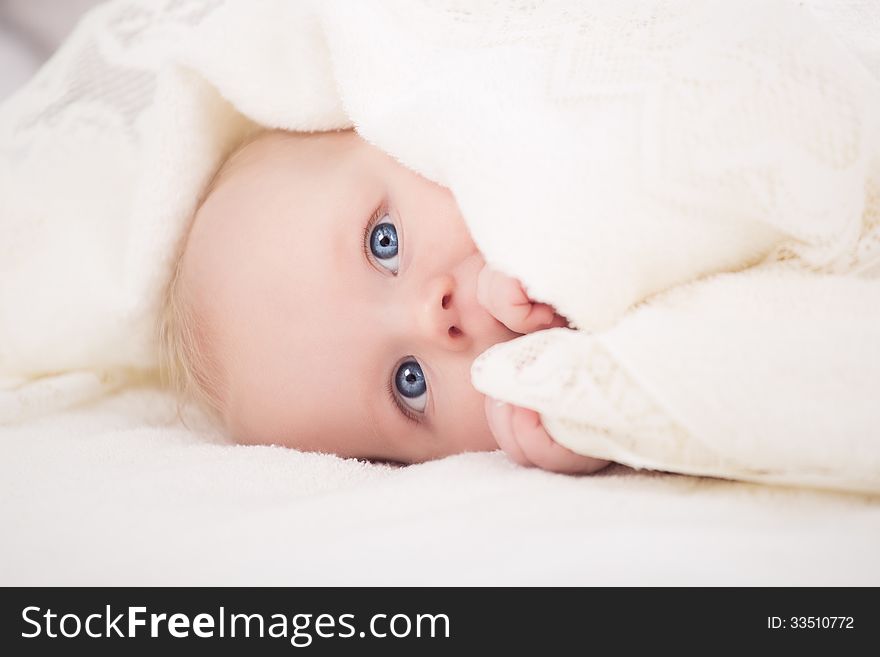 Baby Looking At Camera Under A White Blanket