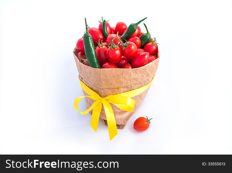 Tomatoes and chili peppers in paper bagisolated on white. Tomatoes and chili peppers in paper bagisolated on white