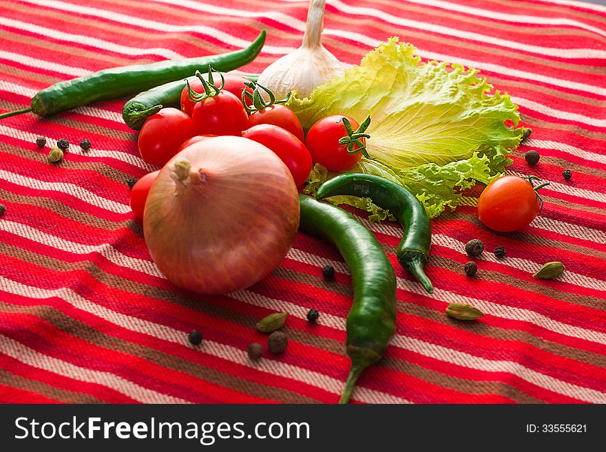 Assorted vegetables and spices on red textured fabric