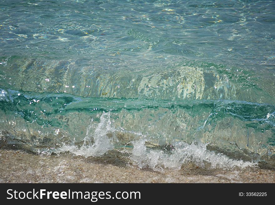 Sea wave on the beach, blue clear water.