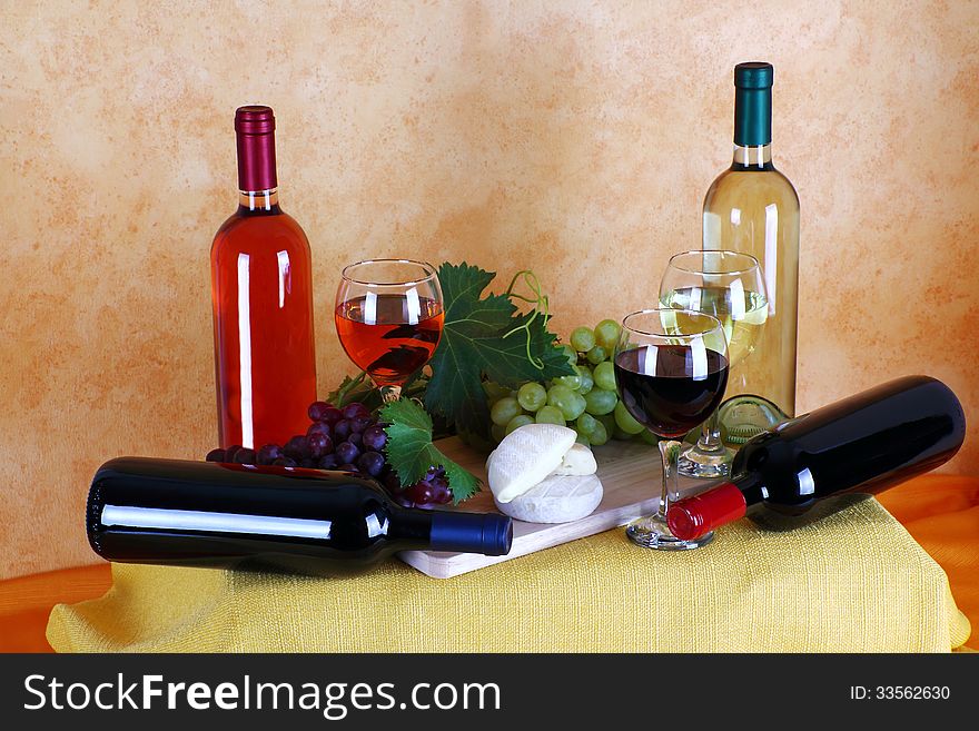 Bottles of red wine, white wine and rose wine with typical Italian cheese and bunches of grapes. Bottles of red wine, white wine and rose wine with typical Italian cheese and bunches of grapes